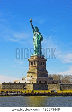 Statue on Liberty Island USA in Upper New York Bay. Tourists nearby.