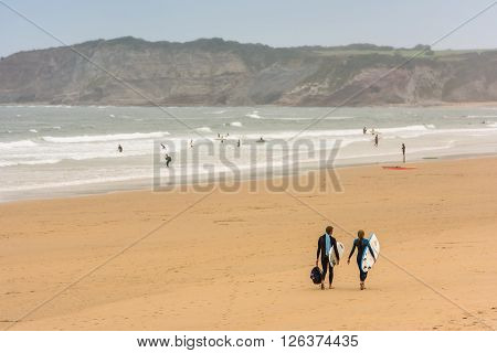 Surfers Walking Together Towards The Ocean