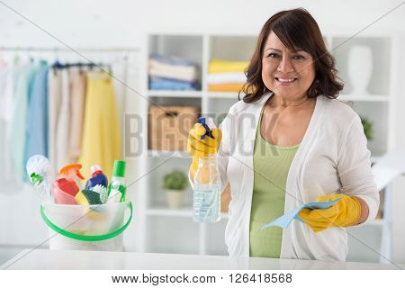 Smiling mature housewife ready to clean the house