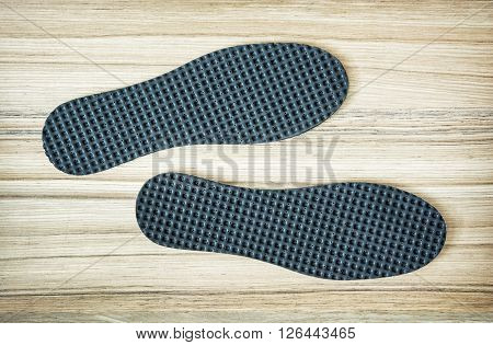 New orthopedic shoe insoles on the wooden background.