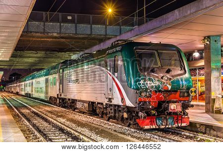 Milan, Italy - May 8, 2014: Class E.464 locomotive hauling a regional train at Milano Porta Garibaldi railway station. Trenord is a regional passenger company in Lombardy
