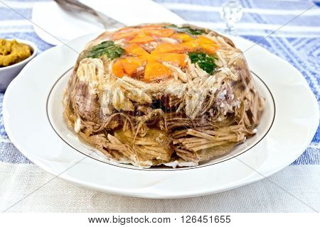 Jellied pork and beef with carrots and parsley on the plate on a mustard background of blue linen tablecloth