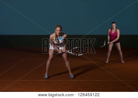 Two Sporty Female Tennis Players Enjoying A Game