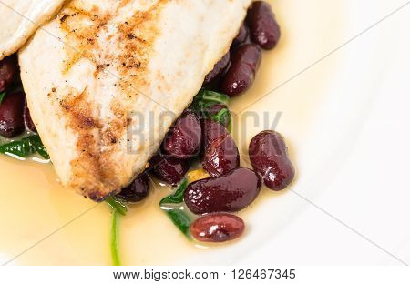 Delicious baked dorado fillet with chard and beans. Macro. Phoro can be used as a whole background.