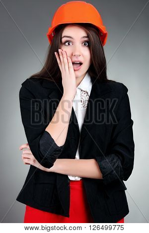 Portrait of emotional girl in construction helmet