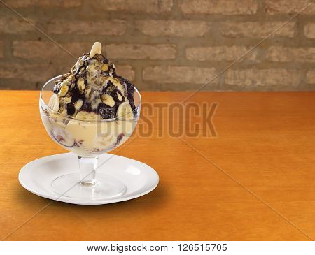 Bowl ice cream with chocolate. Woood background.