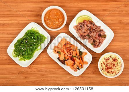 Three Seafood Salads With Sauce On Wood