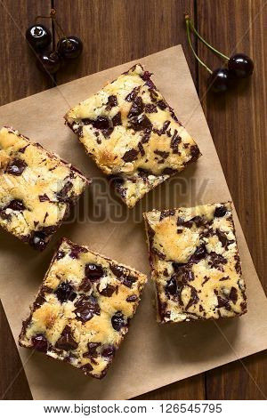 Cherry blondie or blond brownie cake baked with white and dark chocolate photographed overhead with natural light (Selective Focus Focus on the top of the cake pieces)