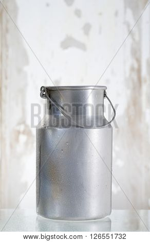 old jug of milk isolated on wooden backgrounf