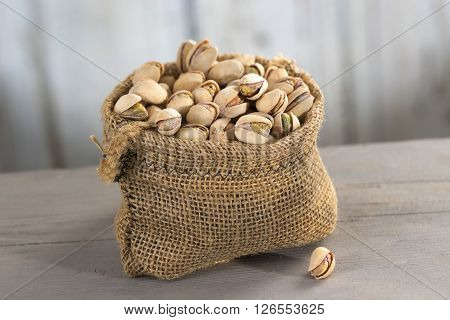 roasted salty pistachios nuts in sack bag, above view