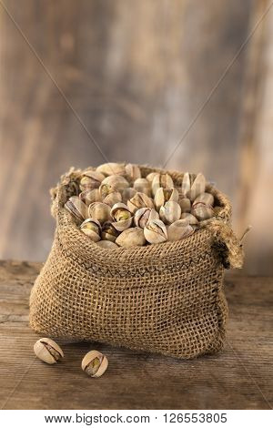 roasted salty pistachios nuts in sack bag, above view
