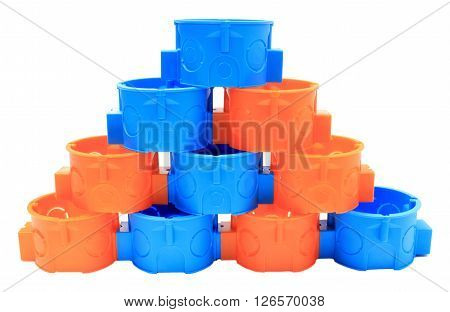 Stack of blue and orange plastic electrical boxes on white background junction boxes accessories for engineering jobs
