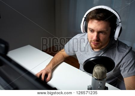 technology, gaming, entertainment, let's play and people concept - young man in headset with pc computer playing game at home and streaming playthrough or walkthrough video