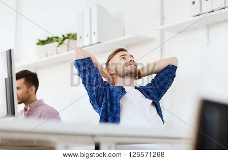 business, technology, education and people concept - happy young creative man or student with computer at office