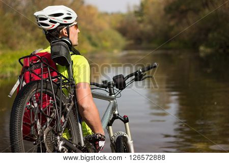 Male cyclist traveling with bike and backpack.