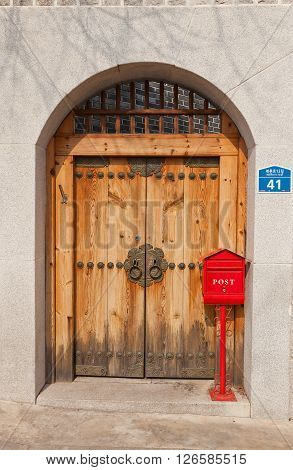SEOUL, SOUTH KOREA - MARCH 14, 2016: Retro style wooden door and red mail box in Folk Bukchon Hanok Village in Seoul Korea. Hanok is a traditional Korean house.