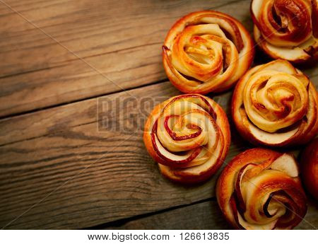 Tasty homemade apple cakes over wooden background