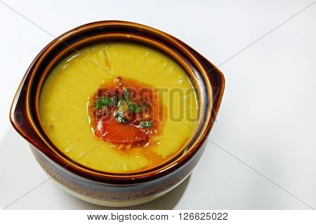 A bowl of Arhar daal lentil with a tempering isolated on white background with copy space.