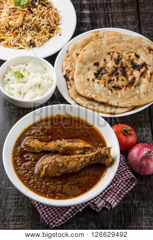 The most popular reddish chicken curry in the UK, india, pakistan, asia, chicken tikka masala, here served in bowl, accompanied by pilau rice and chapatis