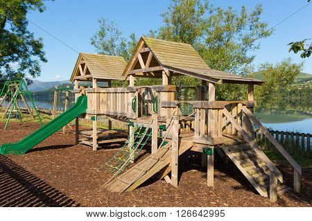 Wooden climbing frame for children in rural outdoor location by a lake
