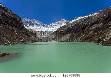 Llaca lagoon (4474 m) in the peruvian Andes and Ocshapalpa peak (5888 m) and Ranrapalca peak (6162 m), Peru.