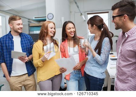 business, communication, startup and people concept - happy international creative team or students on coffee break talking at office