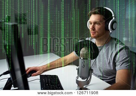 technology, gaming, entertainment, let's play and people concept - young man in headset with pc computer playing game at home and streaming playthrough or walkthrough video