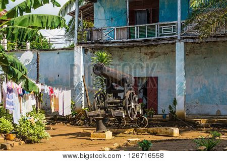 Hell Ville Madagascar - December 19 2015: Old cannon in the courtyard of an apartment house in the town of Hell Ville Nosy Be Island Madagascar. In 1904 - 1905 the Imperial Russian squadron stayed in Nosy Be for four months on the road to war with Japan.