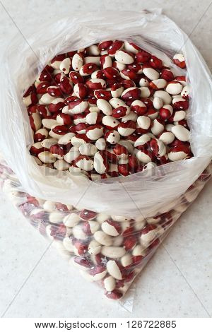 White kidney beans with red spots in the plastic bag close-up. vertical