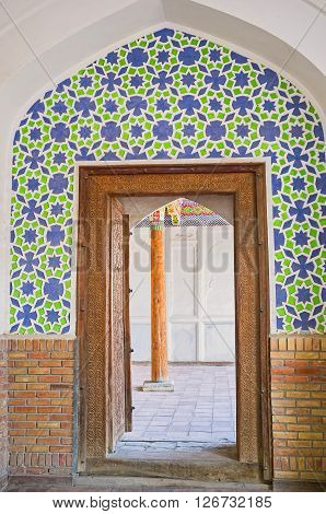 KOKAND UZBEKISTAN - MAY 6 2015: The door inside the Damoi Shakhon Shrine leads to the Iwan and sarcofagi on May 6 in Kokand.