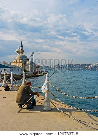 ISTANBUL TURKEY - JANUARY 21 2015: The fishing from the Uskudar embankment located on the Asian shore of the Bosphorus is the popular time spending among the locals on January 21 in Istanbul.