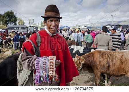 SAQUISILI, ECUADOR - MAY 18, 2014: Indian unidentified, selling handloom woven belts in the Andean market Saquisili­