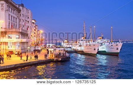 ISTANBUL TURKEY - JANUARY 21 2015: The evening view on Rihtim embankment and the ferries at the Karakoy Terminal on January 21 in Istanbul.