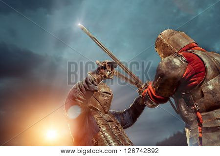 Battle of a Medieval knights on the sunset background.