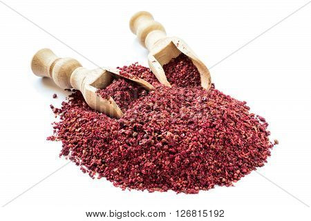 Popular eastern spice sumac in a scoop on a white background