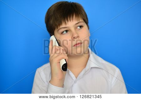 Teen boy talking by a radiotelephony on a blue background