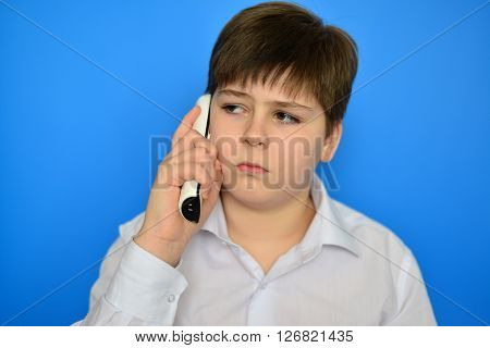 Teen boy talking by a radiotelephony on a blue background