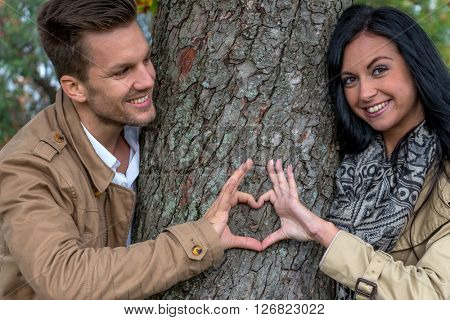 enamoured couple behind a tree