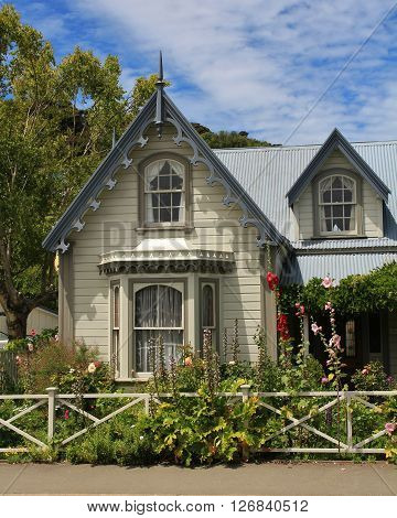 Old house in Akaroa. Beautiful small house with flowers in the front. Scene in Akaroa, New Zealand.