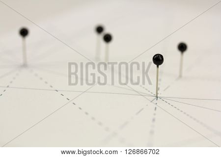 Black Pins In Paper Linked By Lines