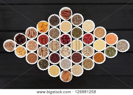 Large dried health food sampler in china bowls forming an abstract background. High in antioxidants, minerals, vitamins and dietary fiber.
