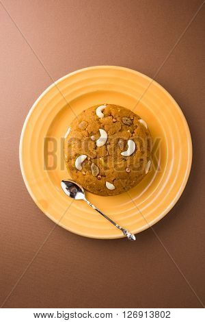 Moong Dal Halwa - a sweet dish from India, Indan Sweet Halwa made from Moong Dal, moong dal sweet sheera or shira cooked in pure ghee, served in a yellow ceramic plate