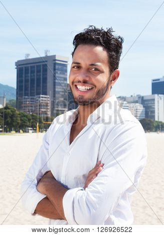 Standing brazilian man looking at camera with skyline of the city in the background