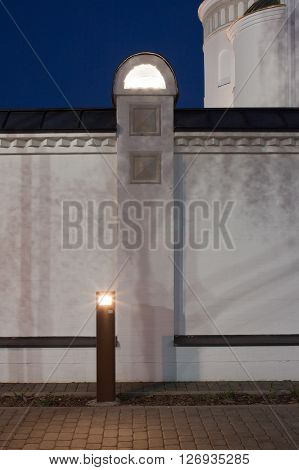 Paving the illuminator. Flagstone sidewalk and bulit in light in fence