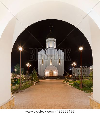 Orthodox temple complex. View through the portal to the temple with evening architectural lighting