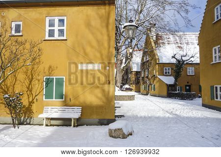 Augsburg Germany - January 17 2016: The Fuggerei is the world's oldest social housing complex still in use. It is a walled enclave within the city of Augsburg Bavaria.