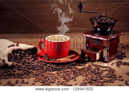 hot coffee and coffee beans on the background of coffee grinders