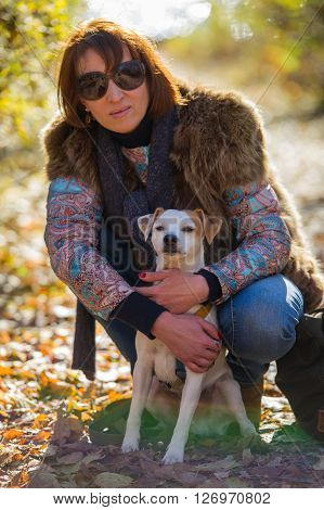 portrait of a woman with a dog on holiday in the autumn park  age of 40 years