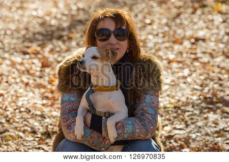 portrait of a woman with a dog on holiday in the autumn park  age of 40 years