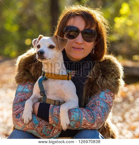 portrait of a woman with a dog on holiday in the autumn park  age of 40 years